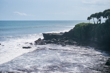 Beautiful landscape with ocean waves and black rock.