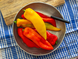 red and yellow peppers on metal plate, top view