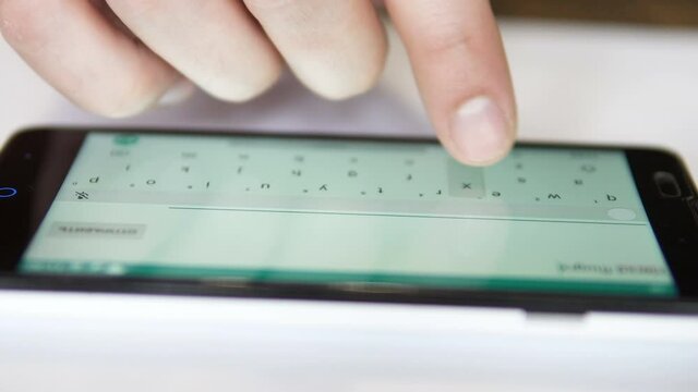 Close up of male hands are typing sms message on the smartphone.