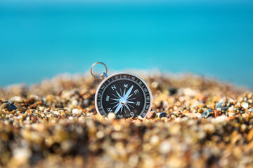 Compass on the sea beach. Selective focus.