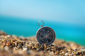Compass on the sea beach. Selective focus.