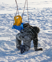 The boy fell from a swing into the snow
