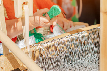 spinning cotton thread with a wooden retro craftsman spinner machine. Culture and tradition concept