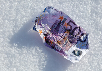 Five hundred Euros lie in the snow.