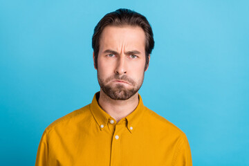 Photo of sad young brunet guy offend wear yellow shirt isolated on blue color background