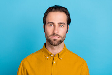 Fototapeta premium Photo of strict millennial brunet guy wear yellow shirt isolated on blue color background