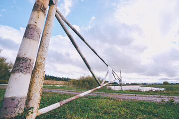 Forgotten gates. Rusty metallic barrier on a countryside road.