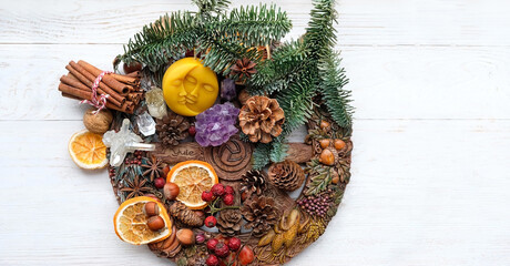 traditional Wiccan altar for Yule sabbath. Sun-moon amulet, wheel of the year, gemstones, cinnamon, nuts, cones, dry orange slices. Esoteric Ritual for Christmas, Yule, Magical Winter Solstice - obrazy, fototapety, plakaty