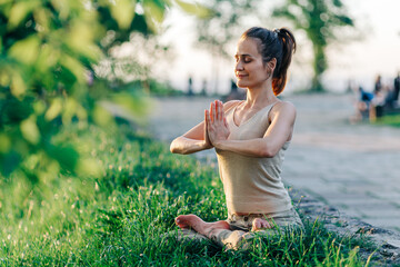 lotus pose, beautiful girl doing meditation on the sunset in the park, yoga, balance, fitness, stretching and relaxation