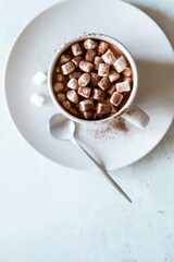 Hot cocoa with marshmallows in ceramic cup on grey table. The concept of winter or fall time. Minimal design. Top view.