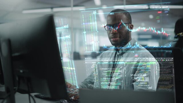 Futuristic Office with Hologram Screens Concept: Portrait of Professional Black IT Specialist Working on Desktop Computer with Holographic Projection Showing Stock Market Information, Big Data, Charts