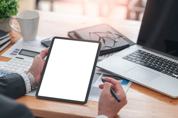 businessman hand holding blank screen tablet while sitting at office desk.