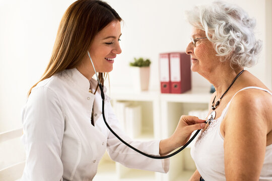 Young doctor with stethoscope exam senior woman