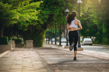 Obraz premium Silhouette of young woman running sprinting on road. Fit runner fitness runner during outdoor workout with sunset background.