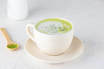 Vegan matcha latte tea with coconut milk in a mug.