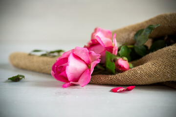 Obraz na płótnie Canvas pink beautiful summer roses on wooden table