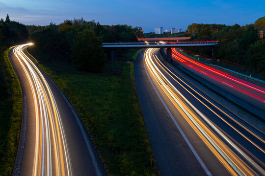 Highway B 236 crossing B 1 in Dortmund Ruhr Basin Germany. Junction at dusk with light traces of passing fast cars and blue evening sky. Long time exposure from a bridge with white and red lights.