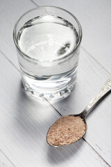 An overhead view of a transparent glass filled with water and husk of psyllium seeds, a healthy superfood
