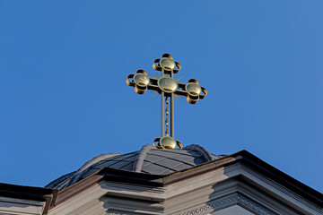 Fototapeta na wymiar Yellow cross on the roof of the church