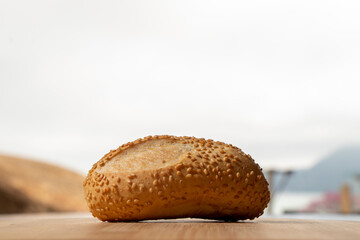 bread with sesame, served on a wooden board for afternoon snack, close-up photo, light background, space for text