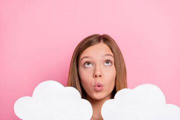 Photo of impressed little brown hairdo girl hold clouds look up isolated on pink color background