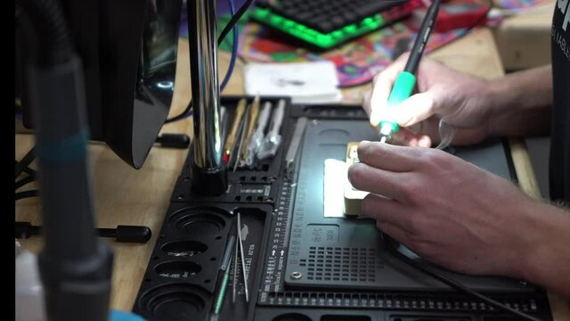 Man repairing a microchip board phone repair shop