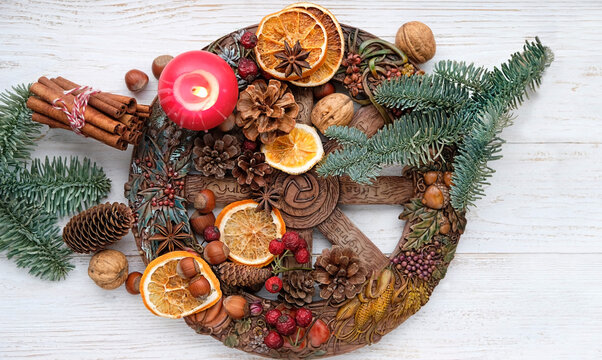 traditional Wiccan altar for Yule sabbath. Wheel of the year, candle, cinnamon sticks, nuts, cones, dry orange slices. Esoteric Ritual for Christmas, Yule, Magical Winter Solstice. flat lay