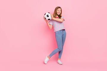 Full size photo of funny teen blond girl hold ball wear t-shirt jeans shoes isolated on pink color...