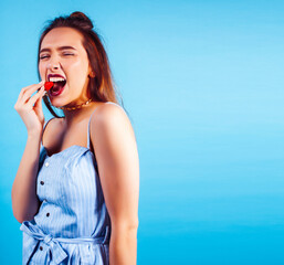 young pretty girl in sunglasses posing happy smiling on blue background, lifestyle people on summer...