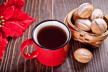 Mug of tea with homemade fresh cookies in a shape of nuts with condensed milk on the wooden table