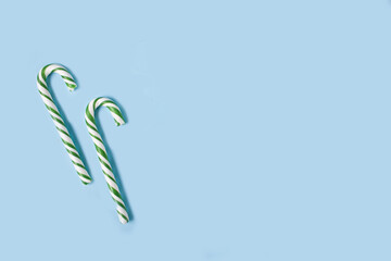 Candy cane on the blue background. Top view. Copy space.
