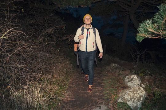 Mature man hiking in forest at night during vacation