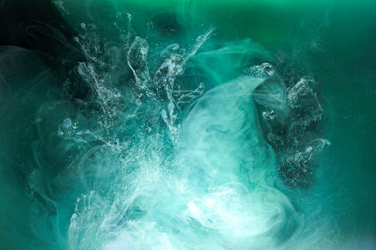Green smoke on black ink background, colorful fog, abstract swirling emerald ocean sea, acrylic paint pigment underwater