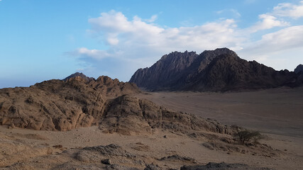 image of the desert and mountains on the Sinai Peninsula at sunset. The Sinai Desert is an attraction accessible to vacationers of all resort areas of Charm.excursion in Egypt.