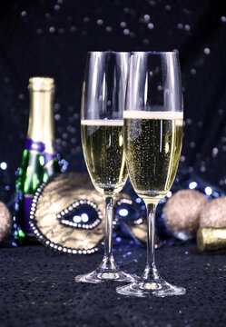 Two glasses of champagne at New Year's Eve party stock images. Two glasses champagne against holiday lights stock photo. New Year party still life images