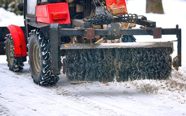 Rotating brush mounted on tractor to clean streets from snow closeup. Sweeping and cleaning...