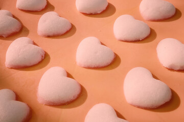 Rows of heart-shaped snowballs on the orange surface. Calming Coral color tones