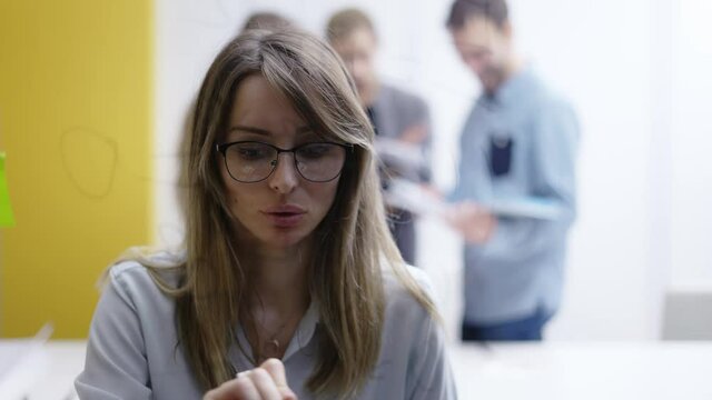 Woman leader on corporate training using glass wall to wite strategy, front view