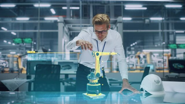 Industry 4.0 High-Tech Factory: Robotics Engineer Working on Robot Arm Design, Using Augmented Reality Hologram to Manipulate 3D Model by Gestures. Futuristic Engineering with Digital Technology