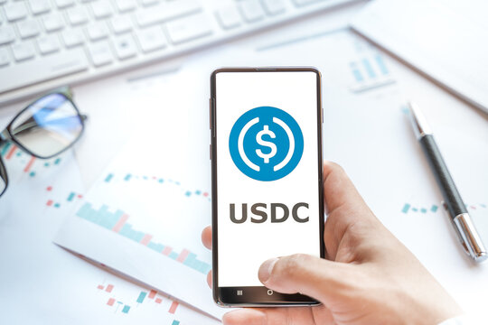 Logo of stablecoin USD coin in tablet. Cryptocurrency stable coin, token. Trading blockchain platform to buy,sell on decentralized exchange DEX,DEFI. Digital money.Business,investing