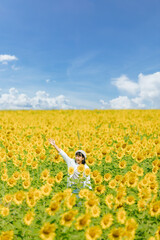Beautiful young woman smiling and looking view of the sunflowers  field landscape. Vacation concept