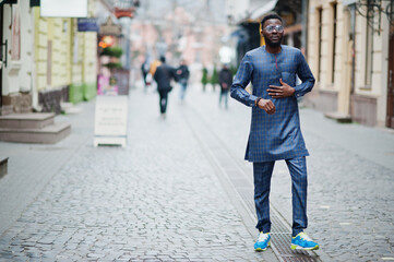 African guy in blue authentic costume, eyeglasses. Fashionable nigerian man.
