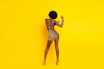 Fototapeta na wymiar Photo of pretty beautiful dark skin woman dressed leopard outfit dancing isolated yellow color background
