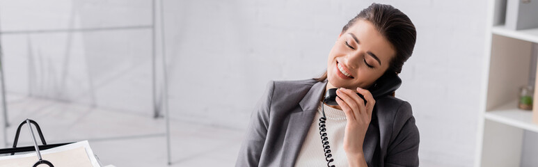 happy businesswoman talking on retro telephone, banner.