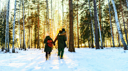 parents and child walking in the winter forest