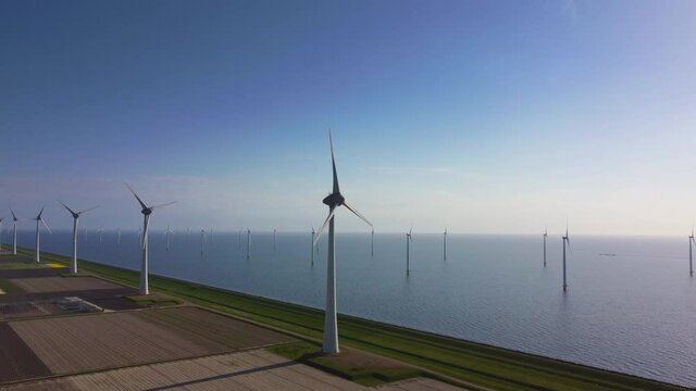 Wind park on a levee and offshore in Flevoland, The Netherlands during a spring day.