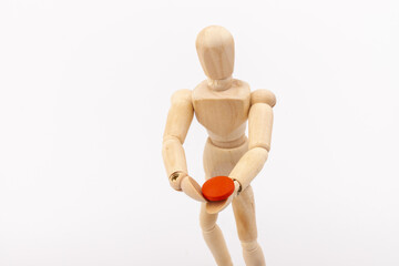 Wooden mannequin with pills on white background. Concept of pharmaceuticals and supplements.