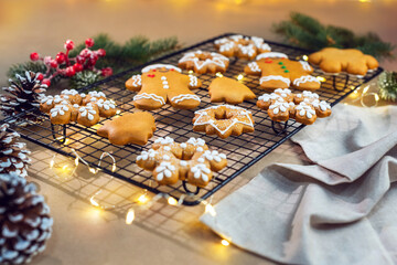 Composition with delicious homemade Gingerbread Christmas cookies on baking rack and parchment paper.