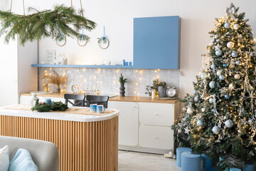 Interior light grey kitchen and red christmas decor. Preparing lunch at home on the kitchen concept. Focus on tree