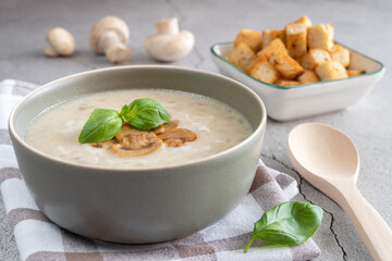 Creamy mushroom soup with fried mushrooms and basil.